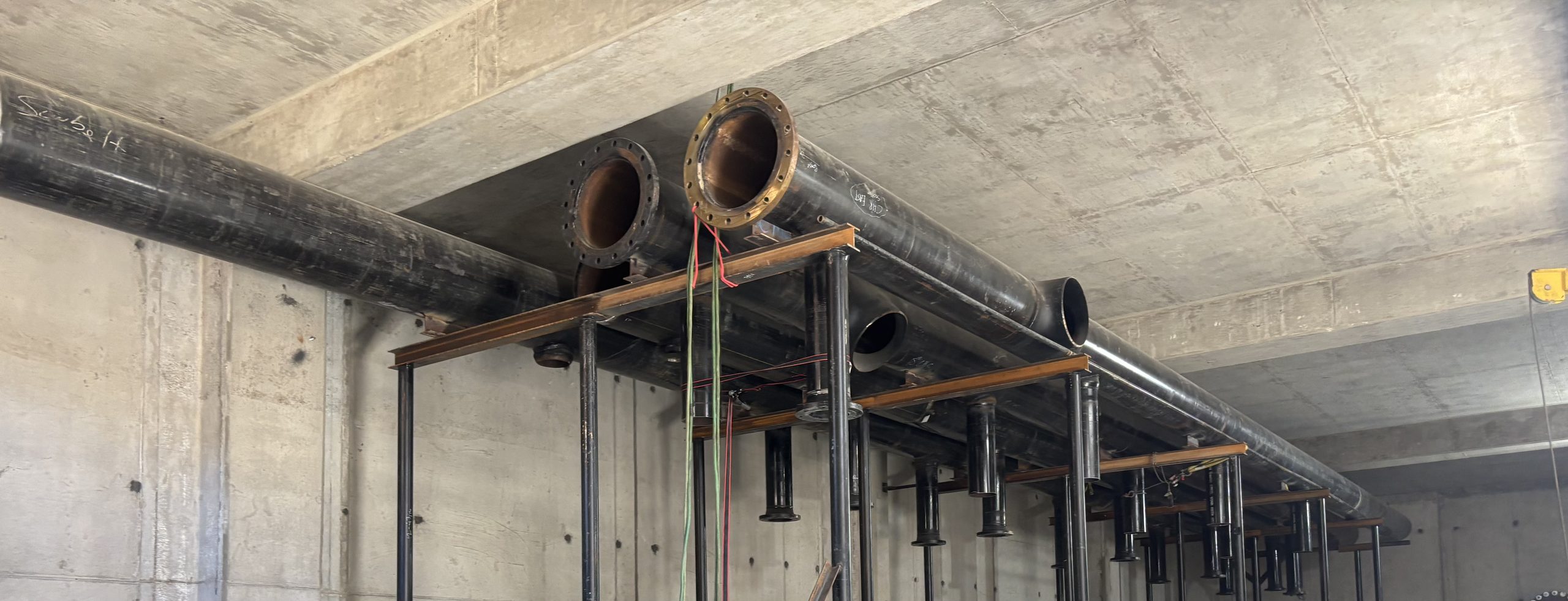 Large-diameter flanged process piping installed on structural supports during an Accuwright mechanical systems installation
