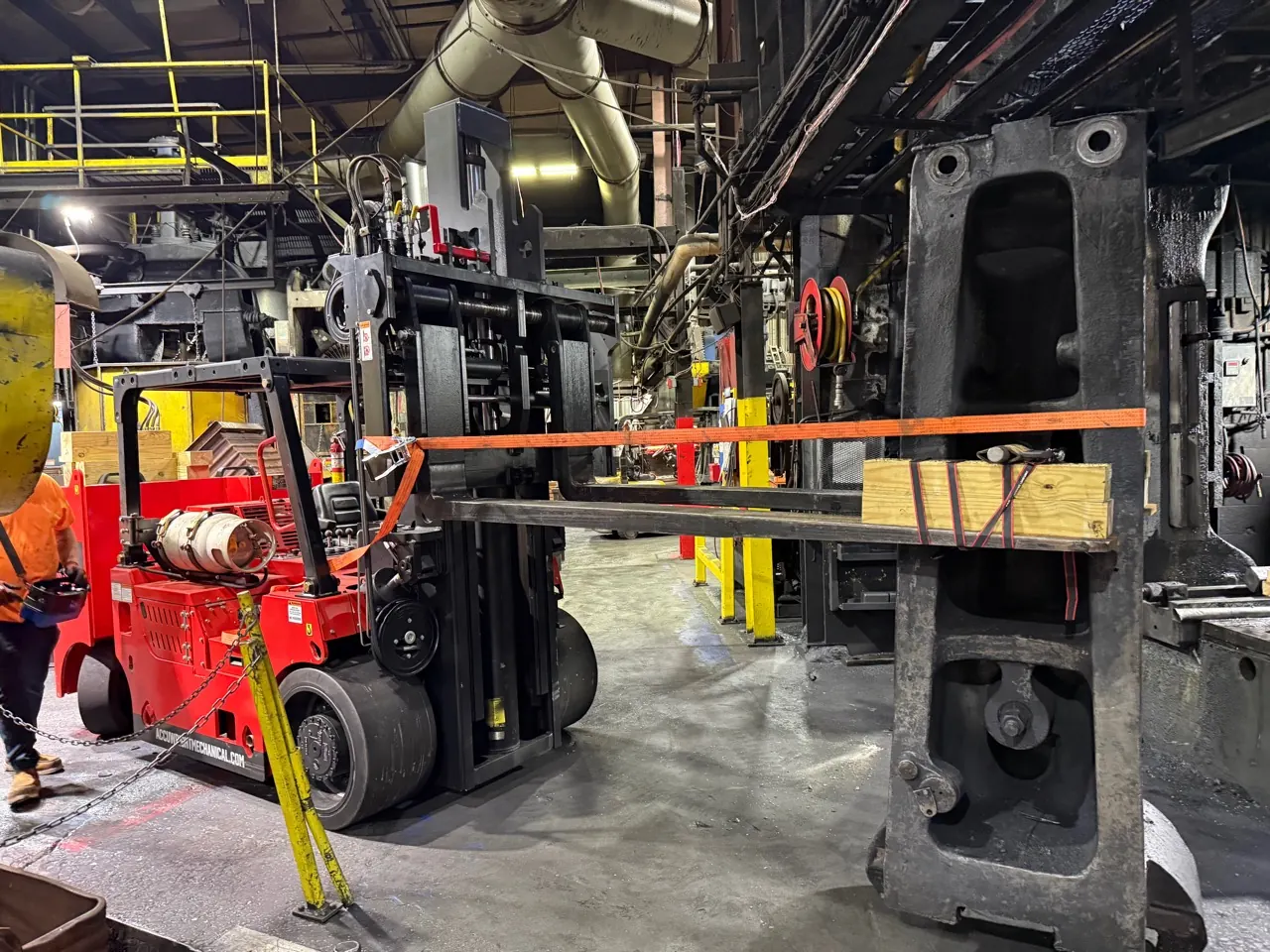 An Accuwright machinery mover carrying a massive cast machine component through a working plant