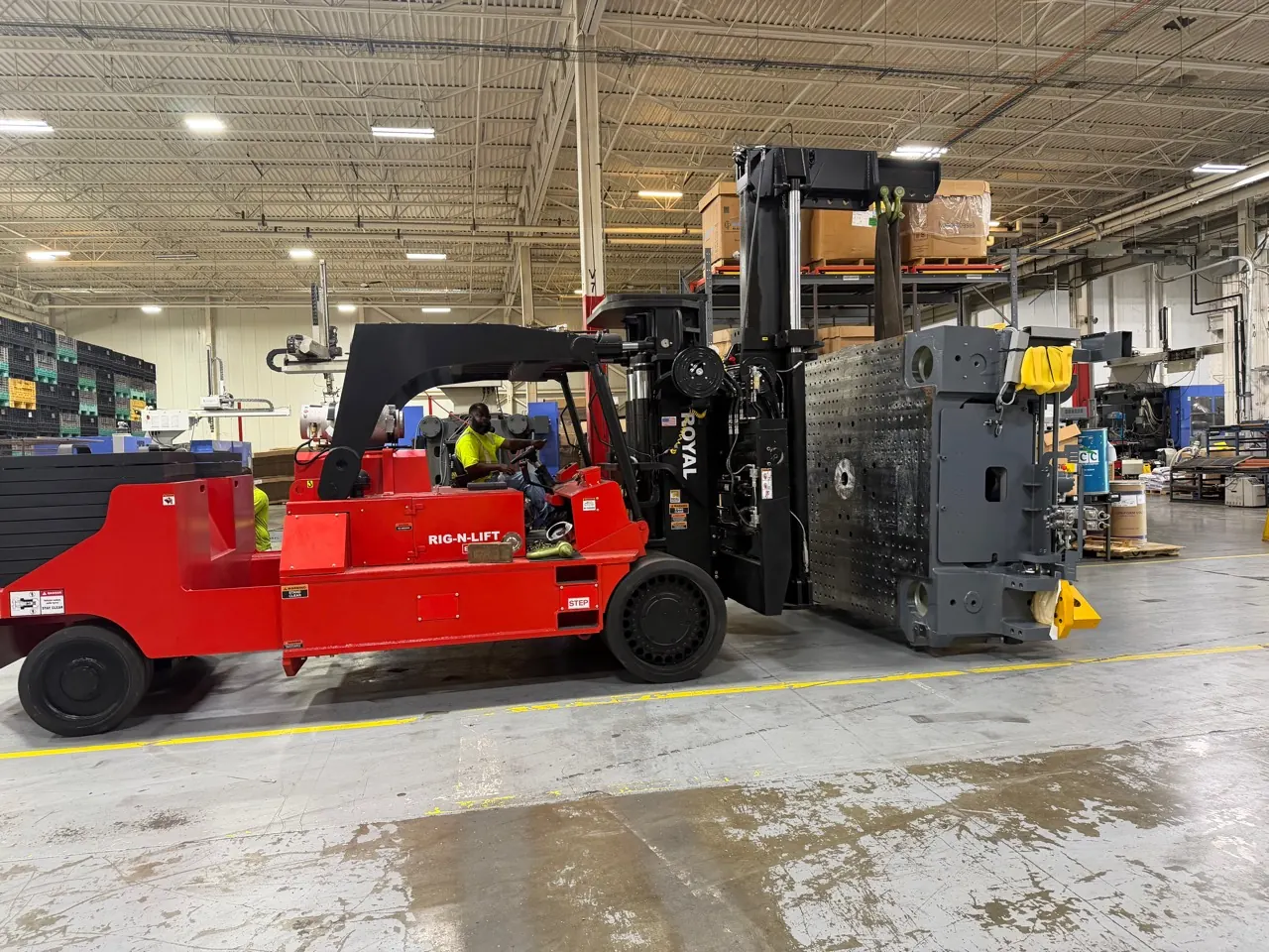 An Accuwright RIG-N-LIFT carrying a large machine platen through a plant aisle