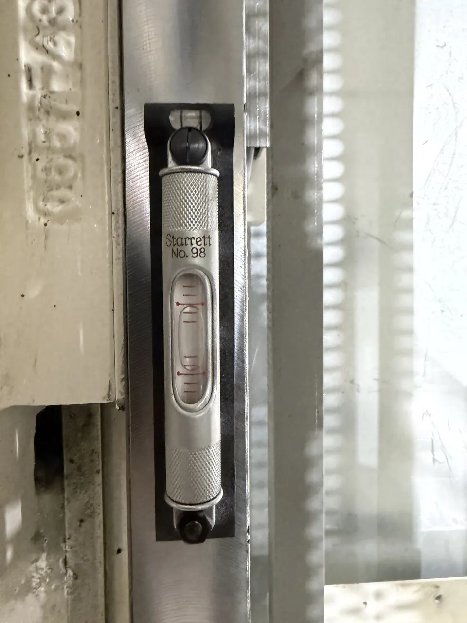 A Starrett No. 98 machinist level reading level on a machined surface