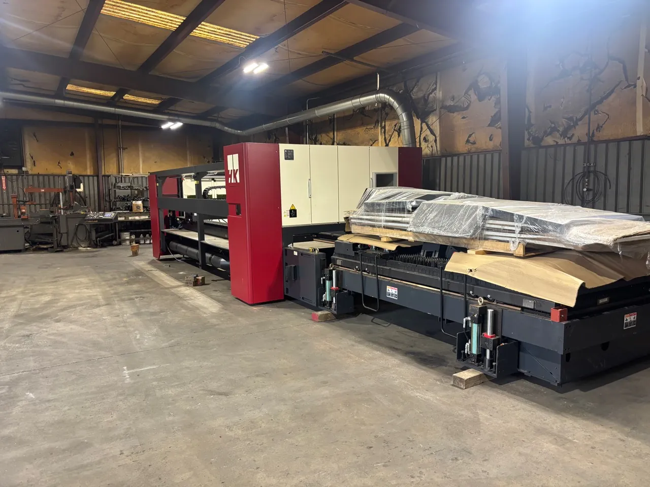 An installed HK laser-cutting system standing in a fabrication shop