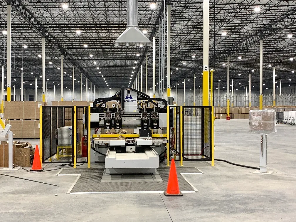 A completed automated machining cell with safety fencing installed in a large clean facility