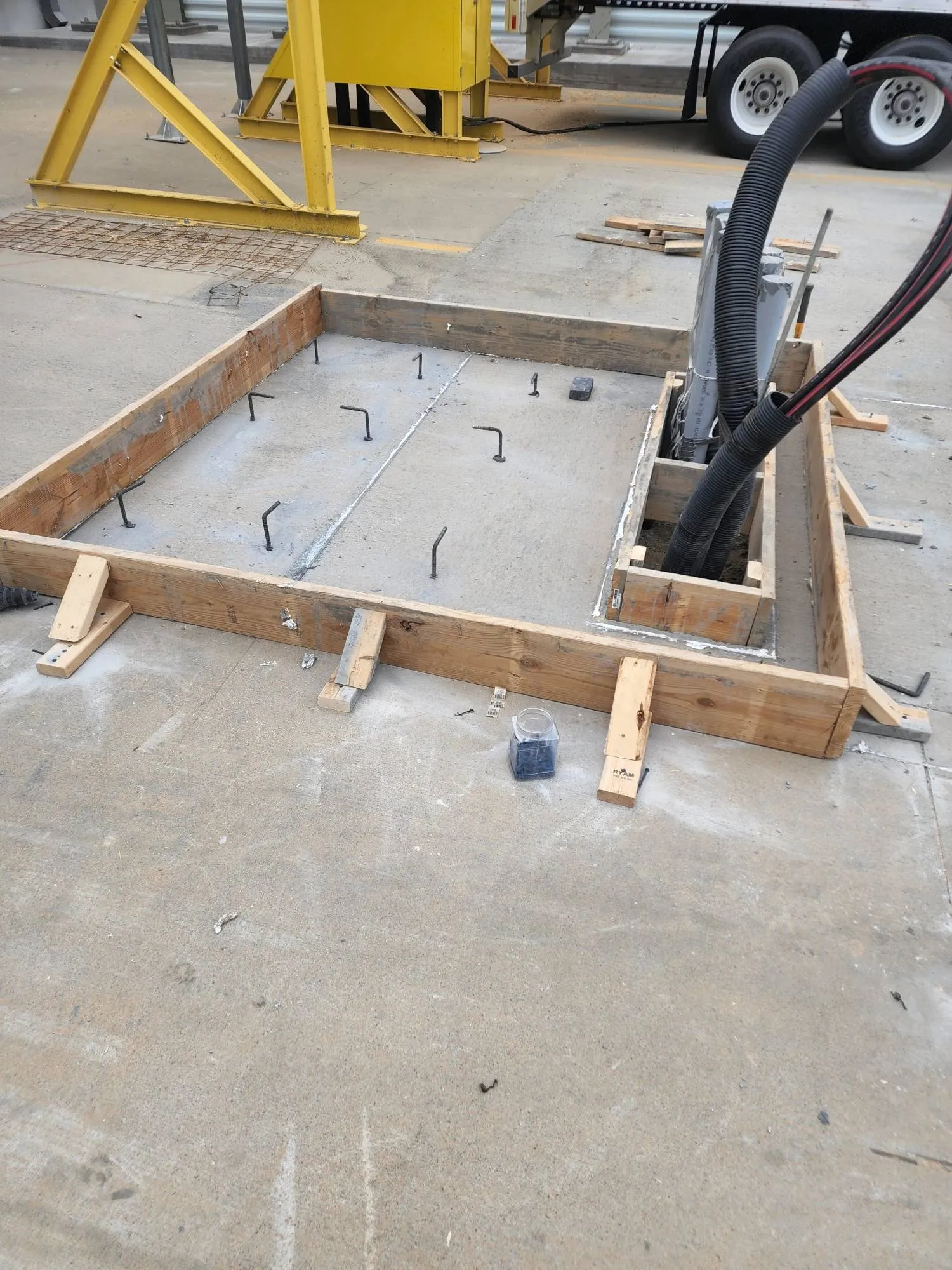 A machine foundation formed with anchor bolts and conduit stubbed up inside the pour