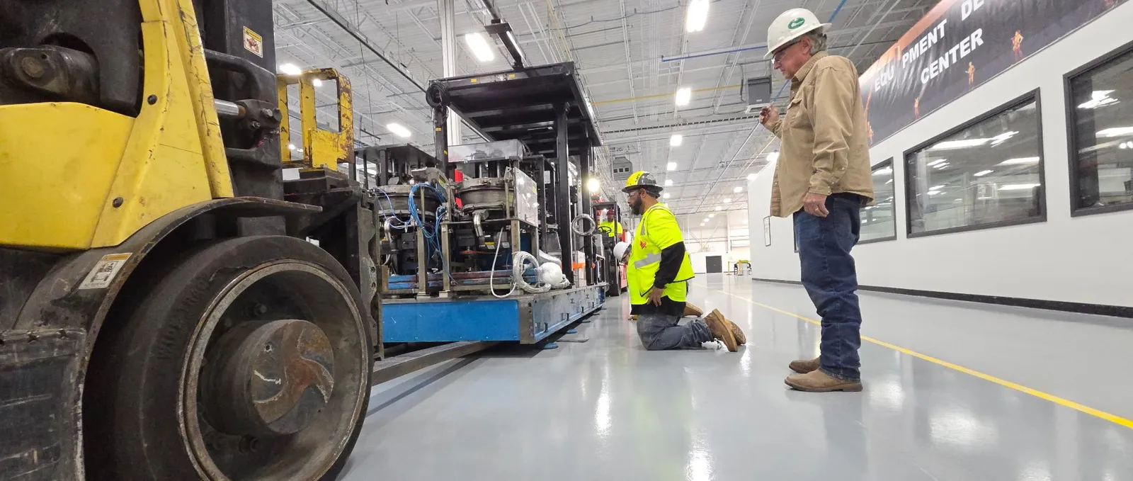 An Accuwright millwright crew setting industrial machinery at its final position on install day