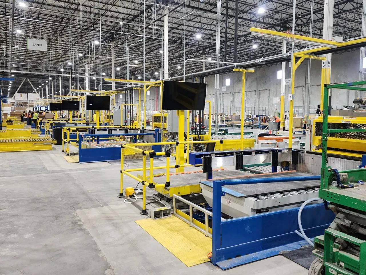 An installed production line with guarding and overhead utilities in a bright, clean plant